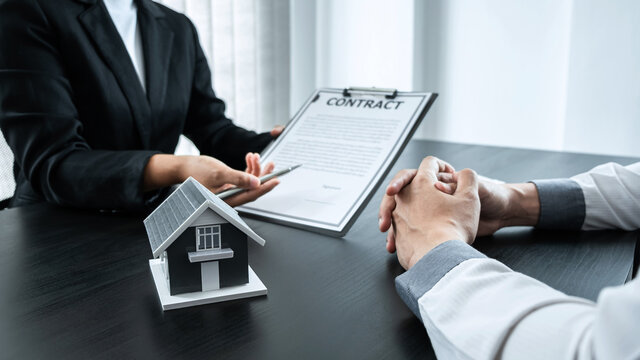 Estate agent broker presentating to client decision signing agreement contract real estate with approved mortgage application, buying mortgage loan offer for and house insurance