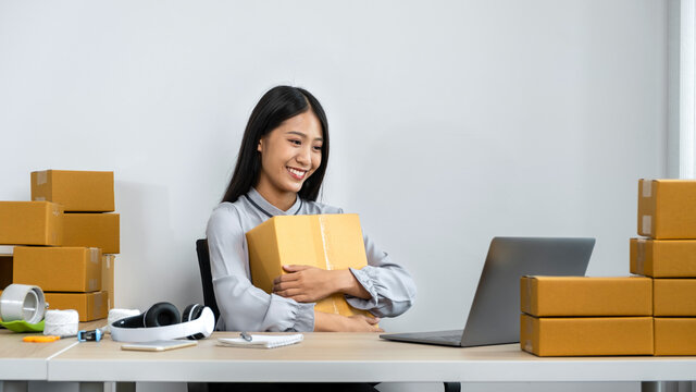 Young Business Woman Entrepreneur Is Smiling And Holding Parcel Box