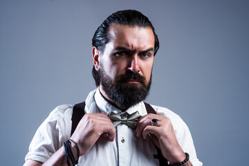 brutal bearded man with moustache wear suspenders and bow tie, retro fashion look