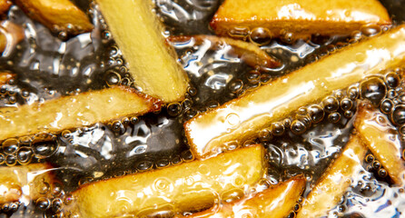 French fries are fried in oil in a pan.
