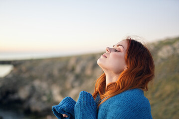 red-haired woman in a blue plaid in the mountains nature fresh air