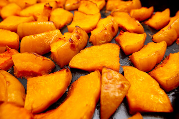 Pieces of pumpkin baked on a baking sheet. Food