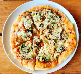 pizza with mushrooms and cheese over wooden background. pizza on a plate.