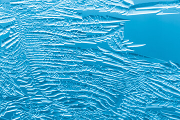 Fototapeta na wymiar Blue patterns from frost on glass as a background.