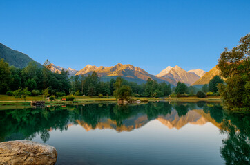 Fototapeta na wymiar Paisaje al amanecer con lago, bosques y montañas en Saint-Lary-Soulan, en Pirineos franceses.