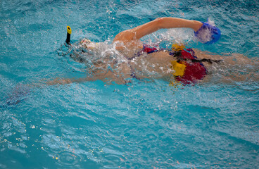 Child athlete swims in the pool.