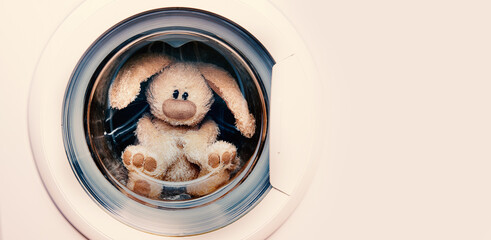 Stuffed rabbit in the laundry with copy space.