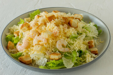 Homemade Shrimp Caesar Salad with parmesa, sauce and Croutons on a white background