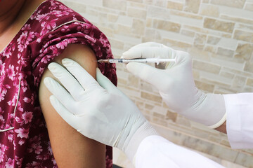close up doctor using syringe to inject Covid-19 or coronavirus vaccine to a patient, omicron cases 