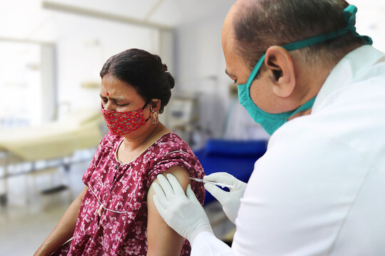 Vaccination In India, Medical Worker Or Doctor Giving Vaccine Injection To A Mature Woman At Hospital To Protect From Coronavirus Or Covid-19. COVISHIELD / COVAXIN Dose.