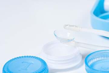 Soft contact lenses with solution, container and tweezers on white background with place for text....