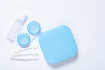 Soft contact lenses with solution, container and tweezers on white background with place for text....