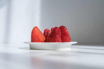 red strawberries in plate on the white table