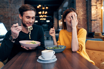 cheerful man and woman sitting in a cafe communicating emotions