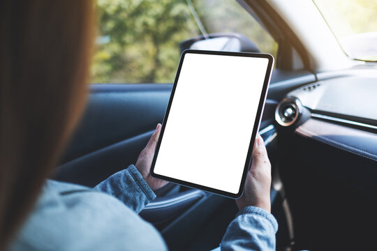 Mockup image of a woman holding and using digital tablet with blank screen in the car