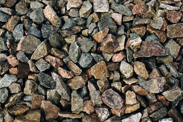 Many brown and grey stones rocks with variegated texture, rough brutal background
