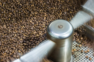 Freshly roasted aromatic coffee beans in a modern coffee roasting machine.
