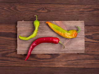 Hot pepper on a wooden board on a dark background.