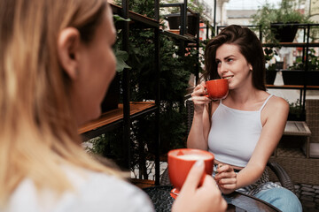 Two Young Women Drinking Coffee in Cafe Outdoors, Lunch Time Concept, Brunette Girl in Focus