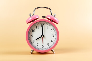Pink alarm clock on a beige background. Time Concept. Place for your text. Copy space.