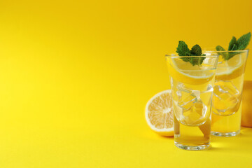 Fototapeta na wymiar Shots with lemon slice and mint on yellow background