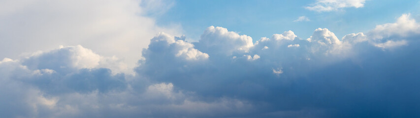 Panorama of the sky with sunlit curly clouds