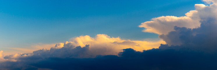 Fototapeta premium Panorama of the evening sky with dark and light sunlit sky. The sky at sunset
