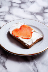 heart-shaped loin toast with cheese on a plate with marble background