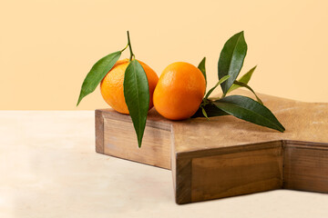 Composition from the fresh mandarins with green leaf on the wooden tray.Isometric beige...