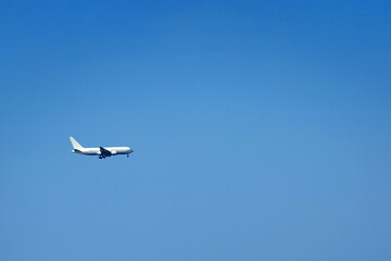 Fototapeta na wymiar A white plane against a clear blue sky