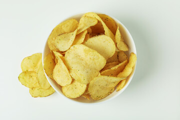Bowl with potato chips on white background