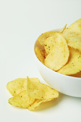 Bowl with potato chips on white background