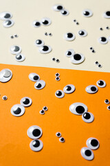 A bunch of toy eyes on an airtight two-color background split in half