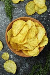 Bowl with potato chips on black smokey background