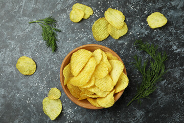 Bowl with potato chips on black smokey background
