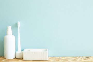Fototapeta na wymiar Skin care and spa concept. Bathroom bottle and toothbrush, soap on wooden shelf. sky blue background