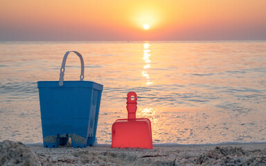 Children's beach toys - buckets, spade and shovel on sand on a sunny day