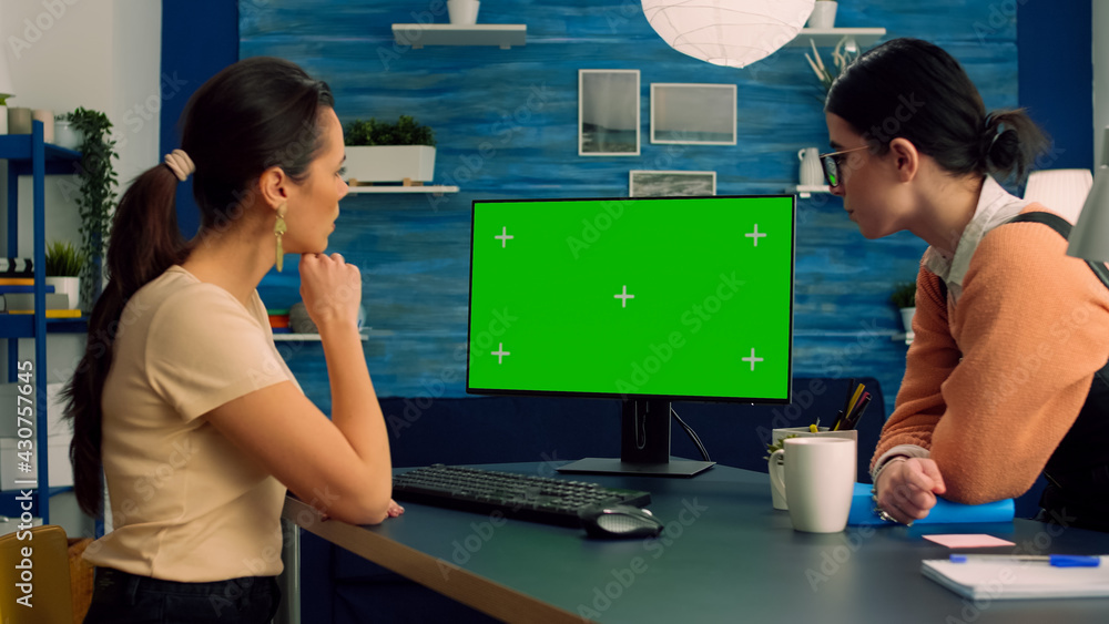 Poster two collegues working together on computer with mock up green screen chroma key display for social m