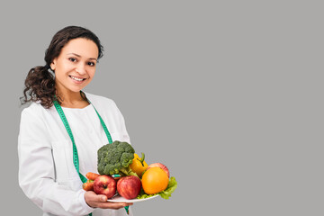 Positive dietitian with fruits and vegetables for healthy eating and diet. Healthy food, dietitian consultation