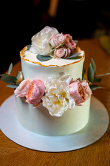 white cake decorated with live flowers. Traditional wedding cake. 