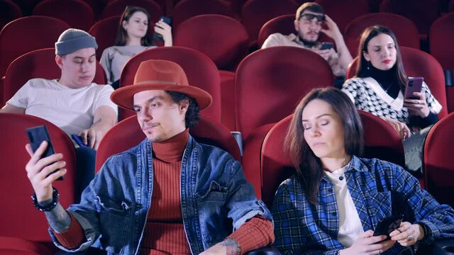 People are getting bored while watching a movie at the cinema