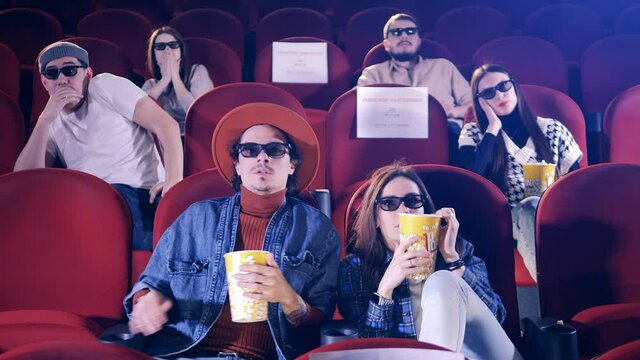 People in 3D glasses are getting scared of the movie. Cinema, movie, entertainment concept.
