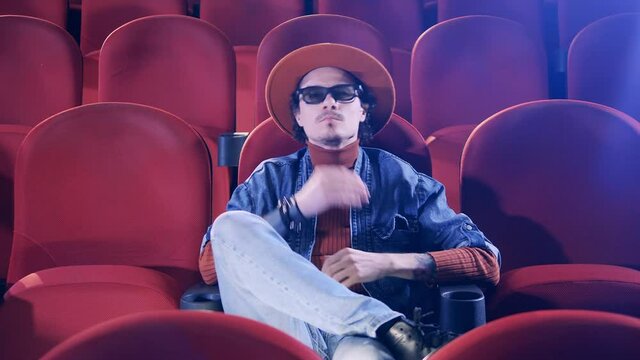 A man puts on 3D glasses while being at the cinema