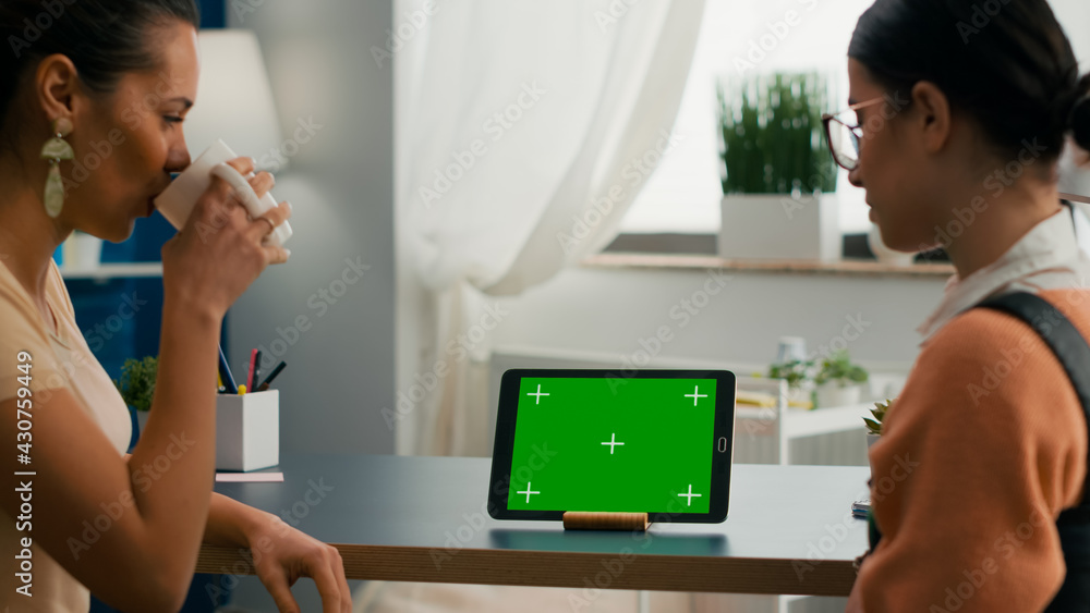 Aufkleber two collegues talking about internet connection in front of tablet computer with mock up green scree