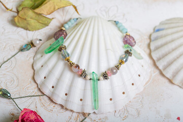 Crystal quartz jewelry necklace on white shell background