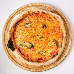 Top view of hot pizza on a wooden stand.