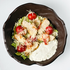 Caesar salad. Juicy slices of chicken steak, fresh lettuce, tomatoes, toasted bacon, parmesan
