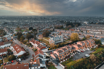 Fototapeta na wymiar Aerial view over the Raheny and James Larkin Rd, Donaghmede, area on the Northside of Dublin. Irish cityscape at sunset viewed from Bull Island.