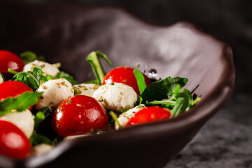 Caprese salad. Fresh arugula, cherry tomatoes, juicy mini mozzarella and a dressing of oregano and olive oil