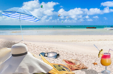 Mise en scène sur plage paradisiaque, parasol, capeline, cocktail, lunettes de soleil, coquillages...
